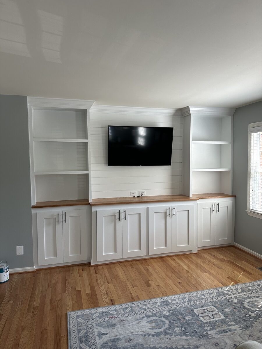 Custom white built-in media wall with shaker cabinetry and shiplap TV panel