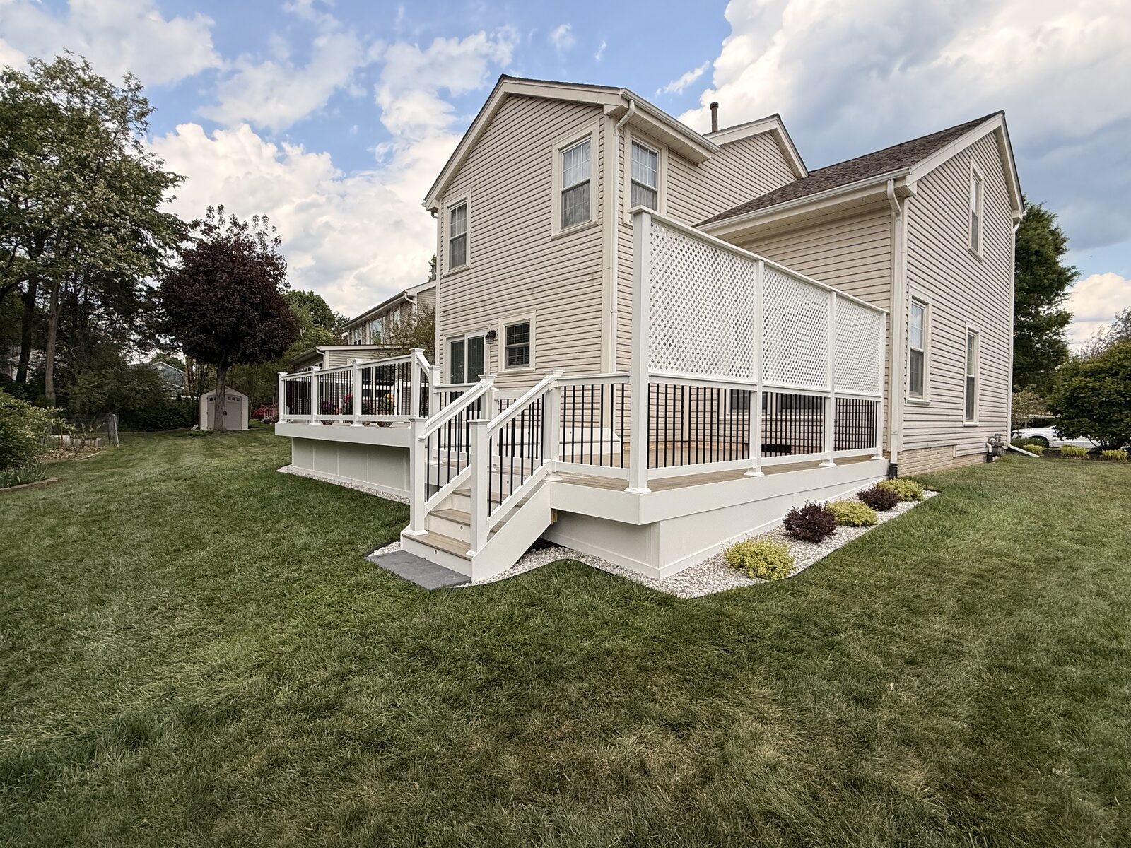 Composite deck with white rail, black balusters, and a white privacy lattice