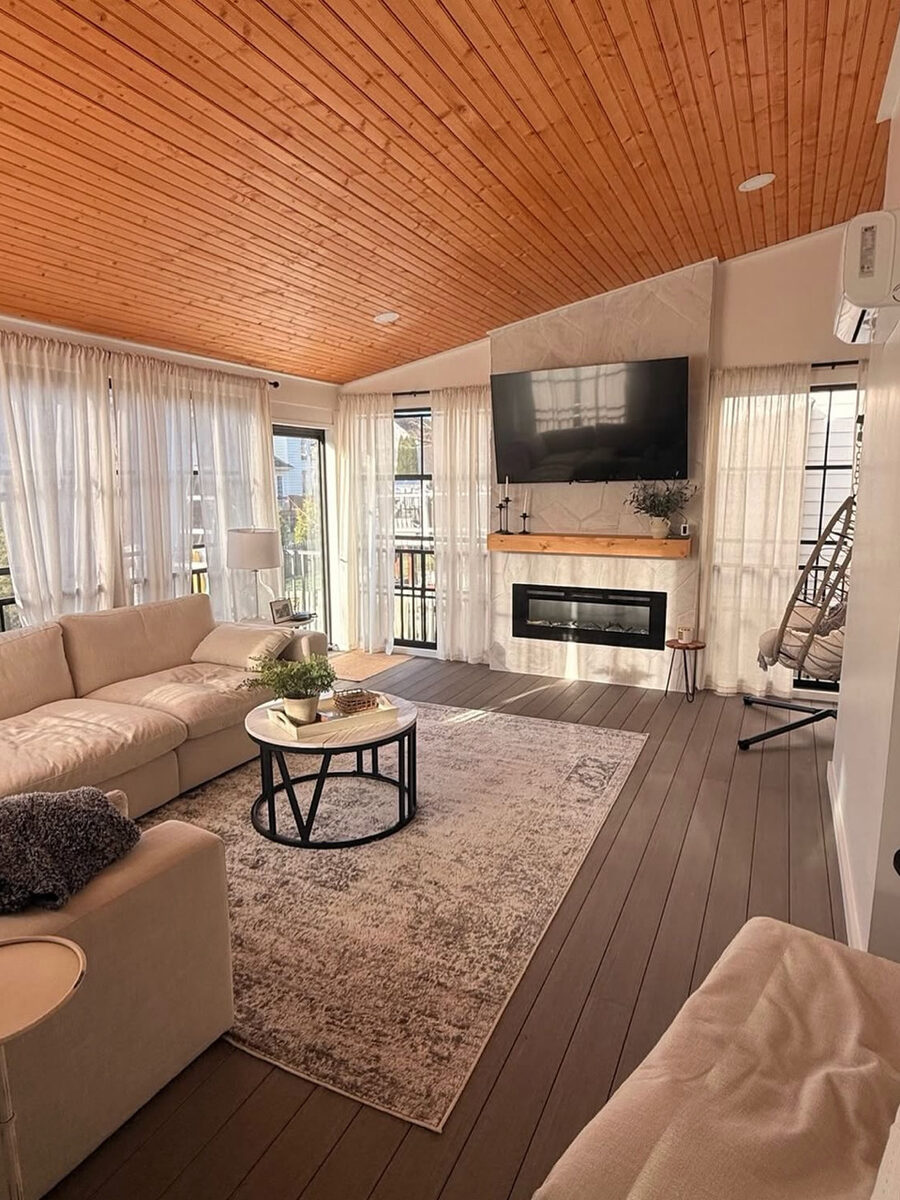 Sunroom with tongue and groove wood ceiling, sectional, and electric fireplace